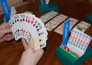在帶有綠色遊戲配件的卡牌遊戲中，雙手拿著撲克牌。