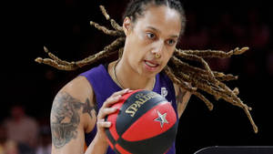 留著長辮子的女籃球員在比賽中拿著 Spalding 籃球。