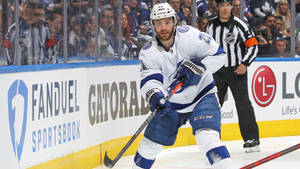比賽期間，冰球球員喺裁判同觀眾嘅陪同下喺板邊溜冰。 — 坦帕灣閃電 壁紙