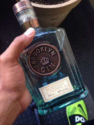 手拿著帶銅封的藍綠色氈酒瓶