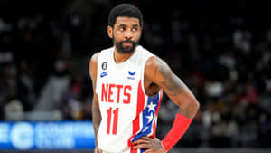 籃球運動員凱里·厄文身穿Nets球衣站在球場上。