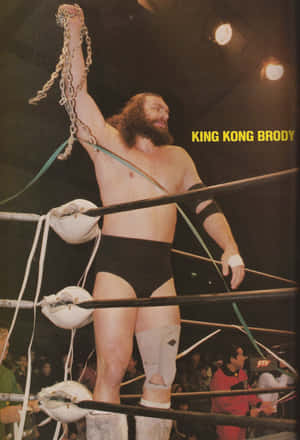 摔角手King Kong Brody在擂台上舉起鐵鏈慶祝勝利。