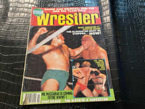 Wrestler雜誌封面，摔角手在擂台上，置於黑色皮革表面。 — 摔角 GIF 壁紙