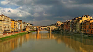 阿諾河上的Ponte Vecchio橋，歷史建築和多雲天空的倒影。 — 日落大道 壁紙