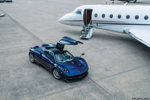 藍色Pagani Huayra跑車停在停機坪上私人飛機旁邊。