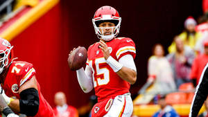 身穿紅色制服的NFL四分衛在比賽中準備投擲橄欖球。