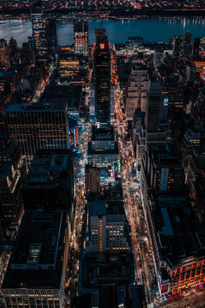密集城市景觀的夜間鳥瞰圖，建築物閃爍，街道燈火通明。 — 紐約市 壁紙