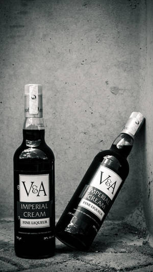 兩瓶V&A Imperial Cream利口酒靠在混凝土牆上。 — 黑白 壁紙