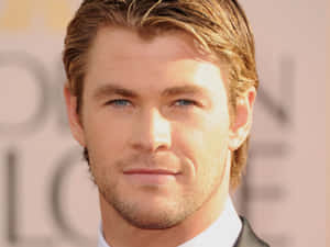 Chris Hemsworth 著西裝出席正式活動，溫暖燈光下。 — 肖像 壁紙