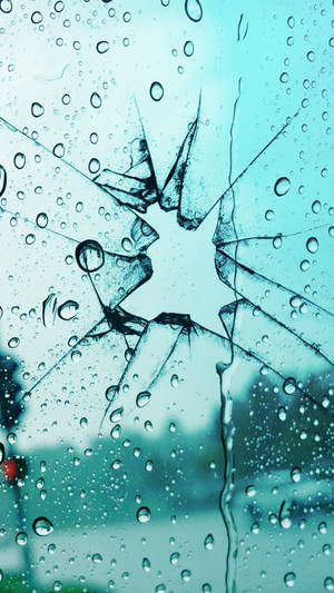 破碎玻璃窗上的雨滴，帶有星形裂紋。 — 手機 壁紙