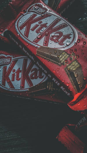 濕紅色KitKat朱古力棒，錫紙包裝上有水珠。 — 糖果 GIF 壁紙