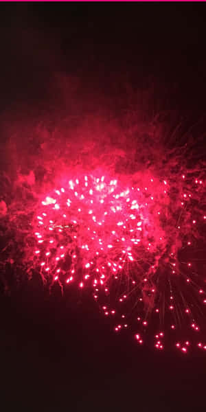 在夜空中爆炸的鮮豔紅色煙火，帶有發光的餘燼。 — 煙火 壁紙