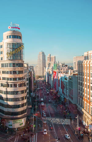陽光明媚的城市街道，高樓大廈和行駛中的汽車。