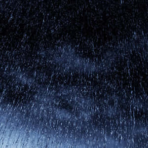 大雨在黑暗的夜空中伴隨藍色燈光落下。