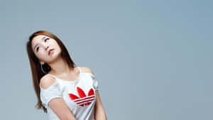 年輕女性穿著白色Adidas T恤，紅色標誌，在攝影棚擺姿勢