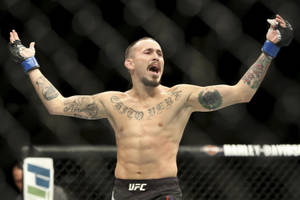 MMA拳手喺UFC八角籠入面舉起手臂慶祝勝利。 — 冠軍 壁紙