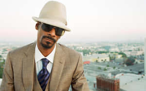 Snoop Dogg 戴著米色紳士帽和西裝，俯瞰黎明時分的城市。