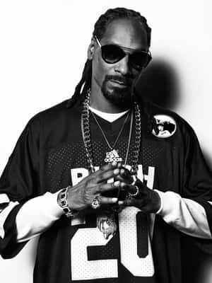 黑白風格的Snoop Dogg戴著太陽眼鏡和珠寶，對著鏡頭擺姿勢。