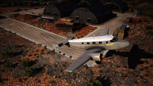 復古軍用飛機停泊在沙漠機場附近機庫旁。 — 飛機 壁紙