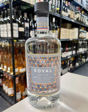 一瓶Koval Dry Gin放在商店櫃檯上，後面有酒架。