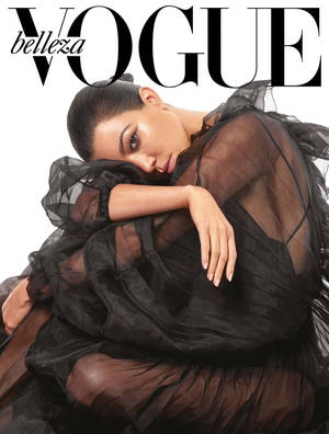 身穿黑色透視裙的模特兒為Vogue雜誌封面擺姿勢。