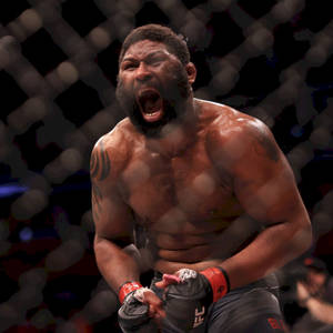 一位肌肉發達的MMA戰士在UFC八角籠中，模糊籠網背景下咆哮。