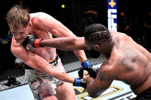兩名男性MMA拳手在血跡斑斑的八角籠比賽中交換強力打擊。