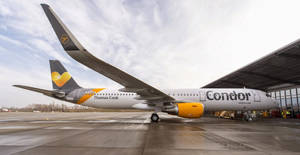 Condor Thomas Cook空中巴士A330停泊在機場閘口，濕滑停機坪，多雲天空