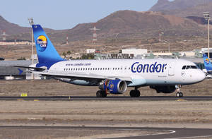 Condor飛機在跑道上滑行，背景有山脈