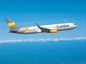 Condor Thomas Cook飛機在藍天白雲下飛越海洋