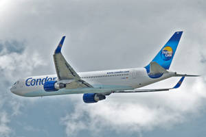 Condor Thomas Cook飛機在多雲天空中飛行