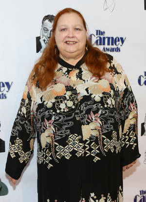 穿著花卉連衣裙的女性在Carney Awards活動中微笑。