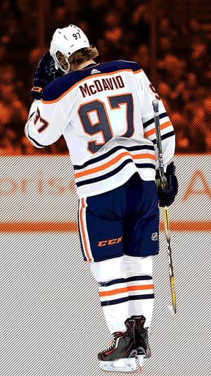 冰球運動員 Connor McDavid 身穿 97 號球衣在冰上手持球棍。 — 冰球 壁紙