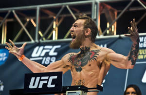 UFC拳手在過磅時高舉雙臂慶祝勝利。
