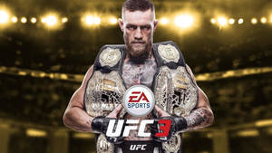 UFC拳手在明亮的競技場中高舉冠軍腰帶，背景有EA Sports UFC 3標誌。 — 康納·麥格雷戈 壁紙