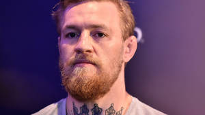 Conor McGregor 紅鬍子及頸部紋身，紫色燈光下的肖像。