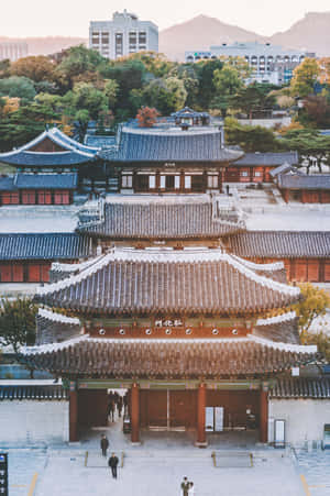 傳統韓國宮殿大門與秋葉和背景中的現代建築。 — Lenovo Legion Y900 11 壁紙