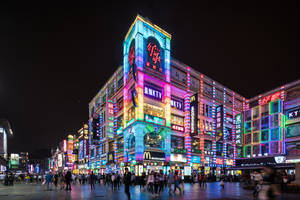夜晚的都市街道，有發光的霓虹招牌和行人。 — 唐人街 GIF 壁紙