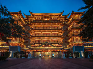 宏偉的中國寺廟在黃昏時分以金色燈光和藍天照亮。 — 唐人街 GIF 壁紙