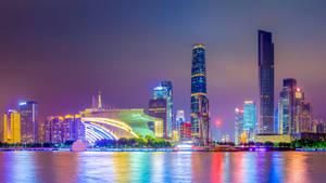 夜晚城市天際線，燈火通明的摩天大樓倒映在水中。 — 唐人街 GIF 壁紙