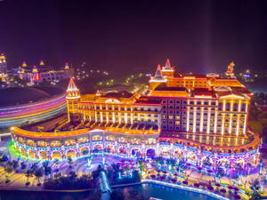 夜間燈火通明的豪華度假村，配有彩色燈光和水景。 — 唐人街 GIF 壁紙