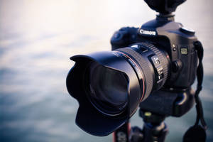 近距離拍攝水邊三腳架上的Canon DSLR相機。