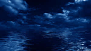 夜晚月光下深藍色海洋反射暴風雨雲層。 — 海浪 壁紙