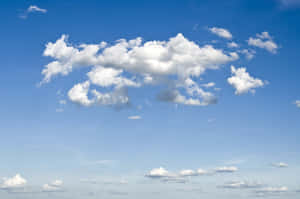 蓬鬆的白雲在晴朗的藍天上飄過，天氣明媚。 — 藍天 壁紙