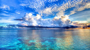 平靜的海洋反射出充滿活力的日落天空，伴隨著戲劇性的雲彩。 — 墨西哥 GIF 壁紙
