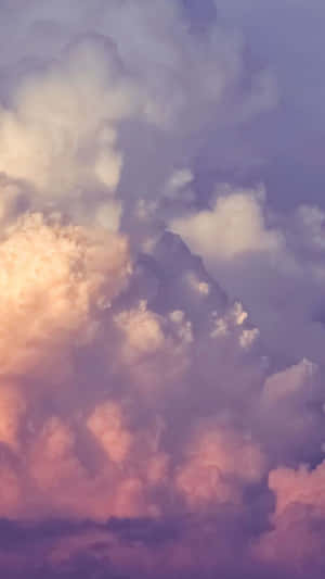 柔和的粉紅、紫色和金色雲彩在暮色天空中閃耀 — 手機 壁紙