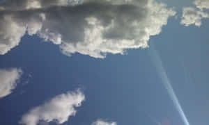 陽光穿過戲劇性的白雲，映襯著深藍色的天空。 — 夏日 壁紙