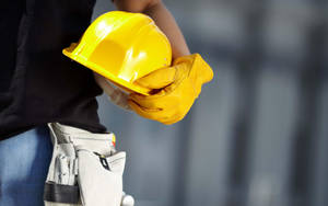 建築工人手持黃色安全帽和手套，佩戴工具腰帶。 — 黃色 壁紙