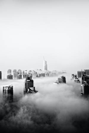 高聳建築從濃霧中浮現，構成單色城市景觀。