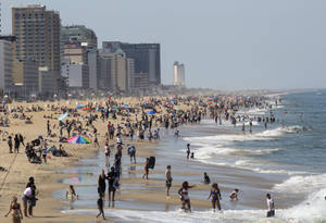 繁忙的海灘場景，人們在城市建築附近游泳和曬太陽。 — 海洋 壁紙